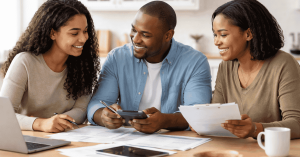Group of people reviewing financial documents together at home, discussing loans and budgeting options using a calculator and paperwork.